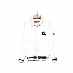 May include: White zip-up jacket with a black and white striped trim. The jacket has a Fila logo on the left chest and a small Fila logo on the right sleeve.