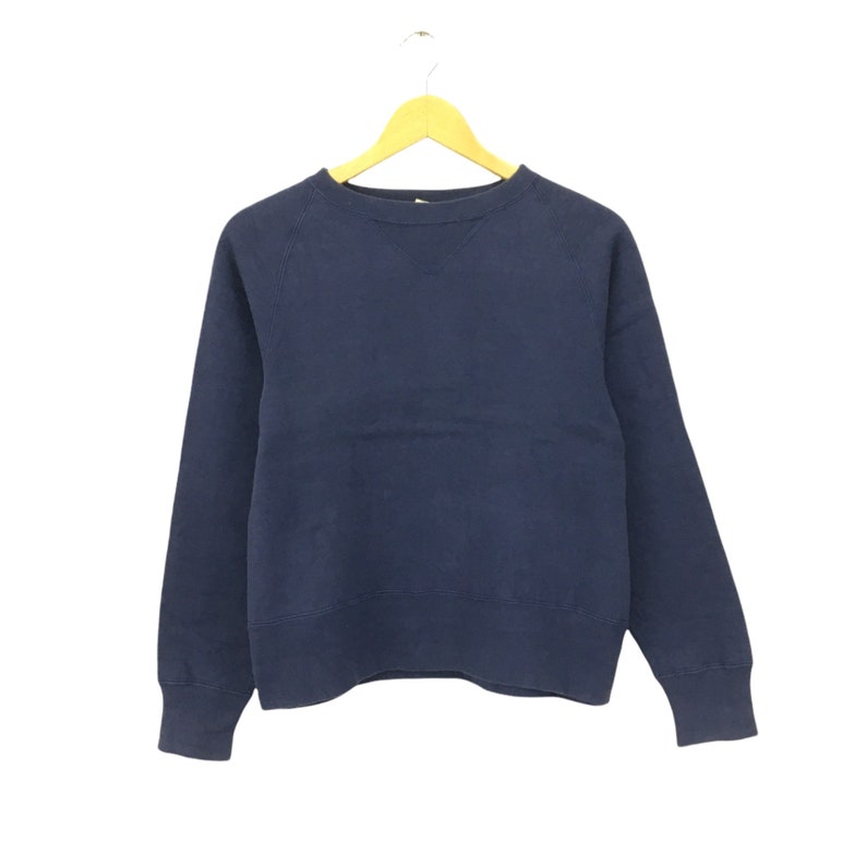 May include: A navy blue sweatshirt with a crew neck and long sleeves.