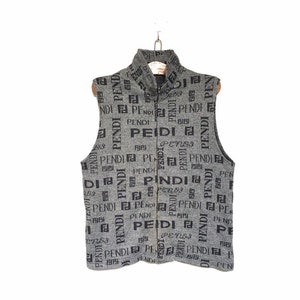 May include: A gray sleeveless vest with a zipper closure. The vest is covered in a black and white all-over print of the word "FENDI".