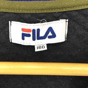 May include: A white tag with the word "FILA" in blue and red letters. The tag also has the number "160" printed on it.