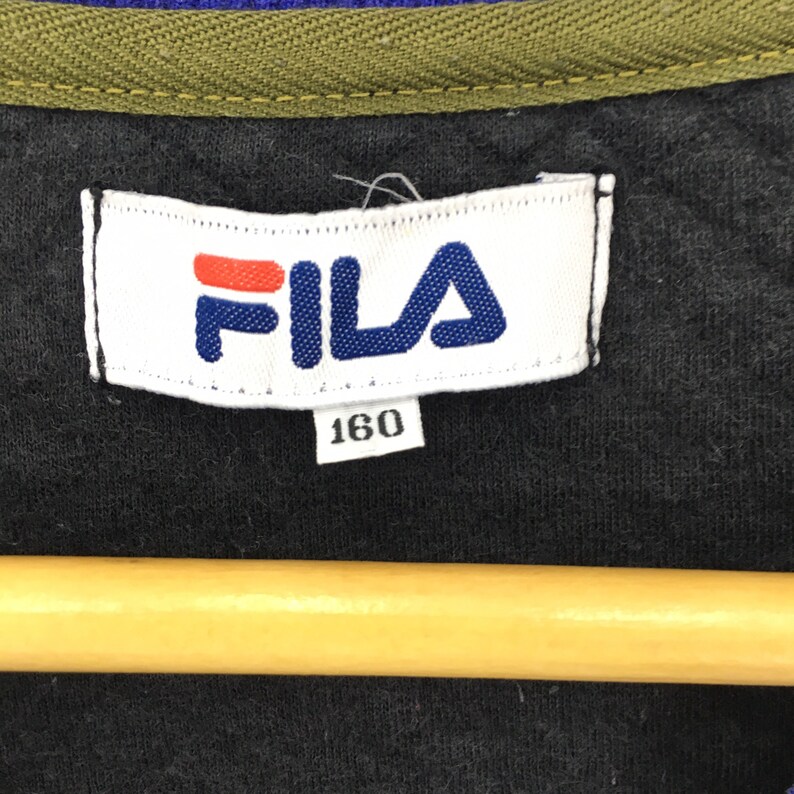 May include: A white tag with the word "FILA" in blue and red letters. The tag also has the number "160" printed on it.