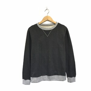 Puede incluir: Una sudadera gris oscuro con cuello y puños de canalé gris. La sudadera tiene una pequeña etiqueta blanca en la parte posterior del cuello que dice "SAINT JAMES PARIS".