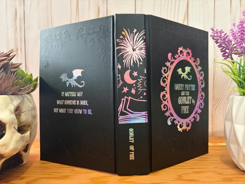 May include: Black book with iridescent accents and the text "Harry Potter and the Goblet of Fire." The book features a dragon emblem and the quote "It matters not what someone is born, but what they grow to be."