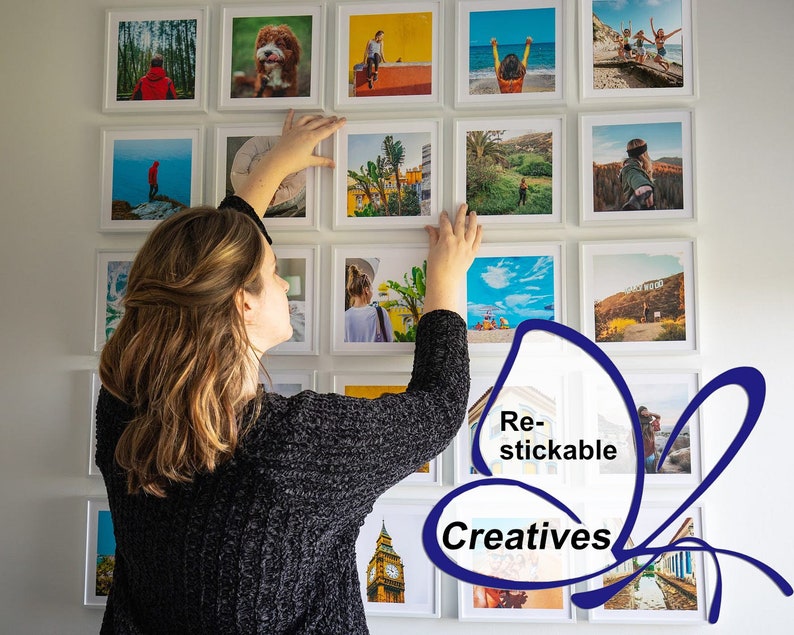 Op de afbeelding: Een vrouw hangt een galeriewand met ingelijste foto's op. De foto's zijn allemaal van verschillende grootte en tonen een verscheidenheid aan onderwerpen, waaronder landschappen, stadsgezichten en portretten. De foto's zijn allemaal afgedrukt op hoogwaardig papier en hebben een matte afwerking. De lijsten zijn allemaal wit en hebben een eenvoudig, modern ontwerp. De tekst "Re-stickable Creatives" is zichtbaar in de rechterbenedenhoek van de afbeelding.