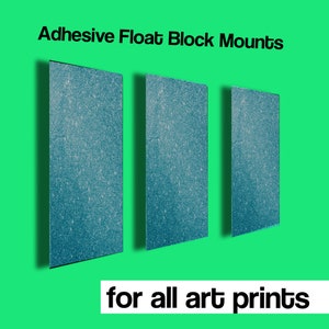 May include: Three blue adhesive float block mounts for hanging art prints.  "Adhesive Float Block Mounts" and "for all art prints" are written in black text below the mounts.
