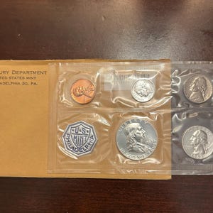Può includere: Un set di monete non circolate della Zecca degli Stati Uniti del 1963 in una busta protettiva. Il set include un penny, un nichelino, una moneta da dieci centesimi, un quarto di dollaro e mezzo dollaro.