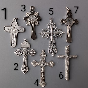 Peut inclure: Collection de sept pendentifs croix argentés, chacun avec des designs uniques. Les pendentifs présentent des représentations détaillées de Jésus-Christ et des ornements. Les croix varient en taille et en style, pour bijoux religieux ou projets artisanaux.