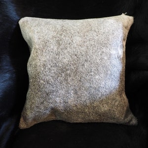 Una hermosa funda de cojín de piel de vaca gris acero suave de marca