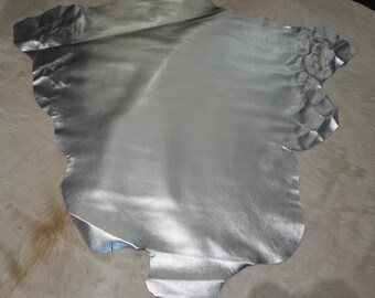 May include: A silver leather hide with a smooth, shiny finish. The hide is irregularly shaped and has a slightly wrinkled texture.