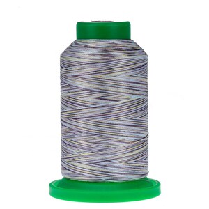 May include: A spool of multi-colored thread with a green plastic bobbin. The thread is a mix of white, beige, and purple.