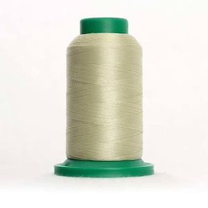 May include: A spool of light beige thread with a green plastic top and base.