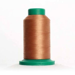 May include: A spool of brown thread with a green plastic top and bottom.