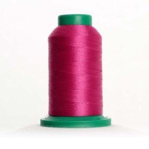 May include: A spool of bright pink thread with a green plastic top and bottom.