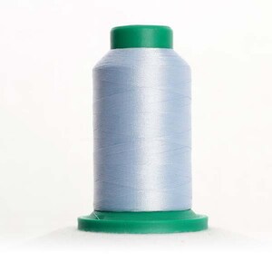 May include: A spool of light blue thread with a green base and top. The thread is tightly wound, creating a cylindrical shape. Ideal for sewing, embroidery, or other textile crafts.