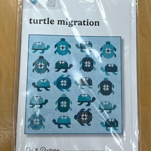 May include: A quilt pattern titled "turtle migration" featuring a light blue background with various turtle designs in shades of blue and teal. The pattern is by Bluebird Patterns and measures 81 x 83 inches.
