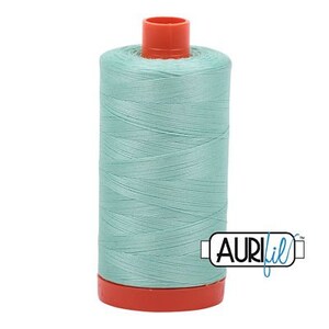 May include: A spool of light blue thread with a red plastic bobbin. The thread is labeled "Aurifil" in blue lettering.