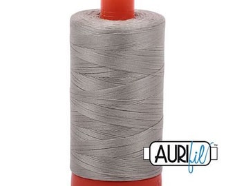 May include: A spool of silver gray thread with an orange plastic bobbin and the word "Aurifil" printed on a blue label.