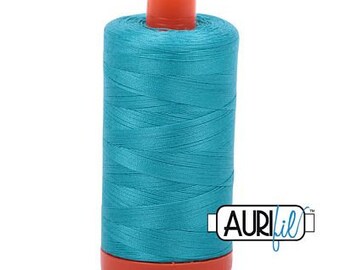 May include: A spool of teal blue thread with a red plastic bobbin and the text "Aurifil" on a white background.