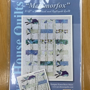 May include: A quilt pattern titled "Metamorfox" in a plastic sleeve. The pattern features a design with blue and green fox shapes and rectangular blocks. The quilt measures 48" x 59". The package includes a smaller image labeled "quilting detail".