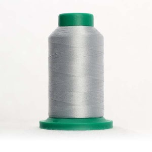May include: A spool of silver gray thread with a green plastic top and base.