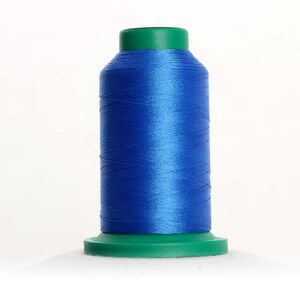 May include: A spool of blue thread with a green plastic top and bottom.