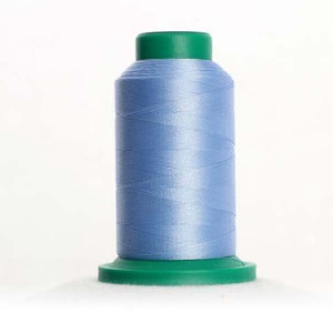 May include: A spool of light blue thread with a green plastic top and base.