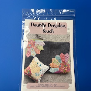 May include: A clear plastic bag containing a sewing pattern. The pattern features a "Double Dresden Pouch" design, with a finished size of 7" x 10". The pattern includes instructions for a mini charm-friendly bonus pincushion. The design features colorful fabric pieces.