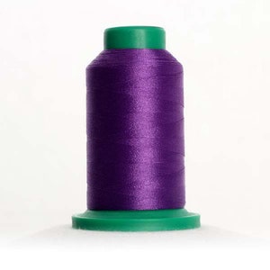 May include: A spool of purple thread with a green plastic top and base.