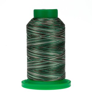 May include: A spool of green, brown, and white embroidery thread. The thread is wound around a green plastic bobbin.