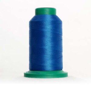 May include: A spool of blue thread with a green plastic top and base.