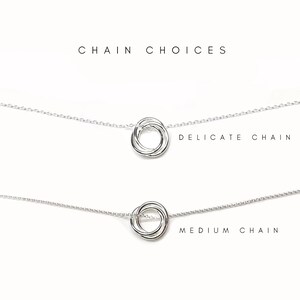 May include: Two silver necklaces with a circle pendant. The top necklace is labeled "Delicate Chain" and the bottom necklace is labeled "Medium Chain".