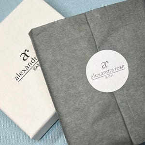 May include: Two white boxes with black text. The text on the top box reads "ar. alexandra bath". The text on the bottom box reads "ar. alexandra rose bath".