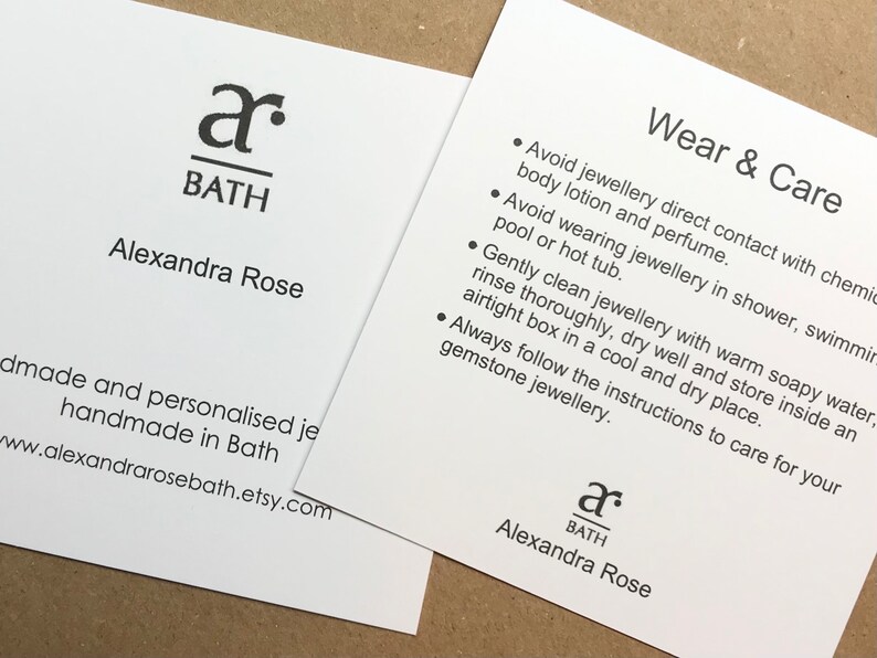 May include: White card with black text. The text reads "a BATH Alexandra Rose" and "Wear & Care" with a list of instructions for caring for jewelry. The card is a business card for a jewelry maker.