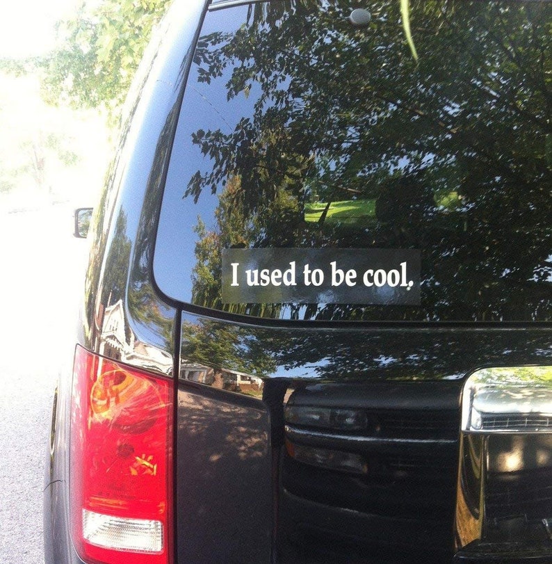 May include: A black car with a white sticker on the back window that says "I used to be cool."