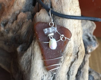 Colgante de vidrio de mar envuelto en alambre en marrón.  Envuelto con alambre de tono plateado