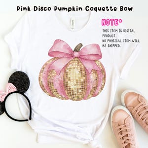 May include: A white t-shirt featuring a pink and gold glitter pumpkin with a pink bow. The text "NOTE* THIS ITEM IS DIGITAL PRODUCT. NO PHYSICAL ITEM WILL BE SHIPPED." is on the shirt.