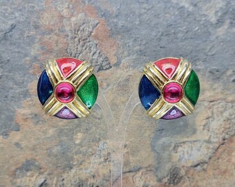 May include: A pair of round, multi-colored earrings with a gold-tone metal frame. The earrings feature a red, green, blue, and pink enamel design with a pink rhinestone in the center.