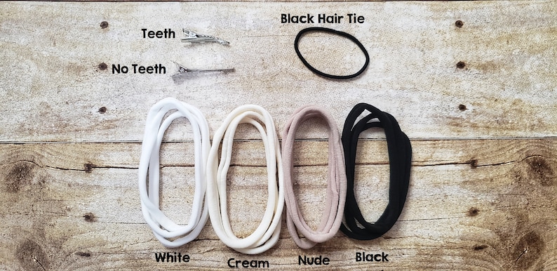 May include: Four hair ties in white, cream, nude, and black colors.  A black hair tie is also shown separately. Two silver hair clips are shown with the text "Teeth" and "No Teeth".