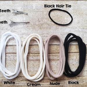 May include: Four hair ties in white, cream, nude, and black colors.  A black hair tie is also shown separately. Two silver hair clips are shown with the text "Teeth" and "No Teeth".