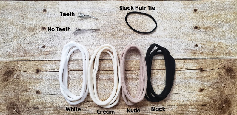 May include: Four hair ties in white, cream, nude, and black colors.  A black hair tie is also shown separately. Two silver hair clips are shown with the text "Teeth" and "No Teeth".