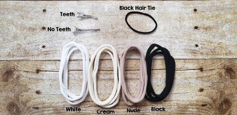 May include: Four hair ties in white, cream, nude, and black colors.  A black hair tie is also shown separately. Two silver hair clips are shown with the text "Teeth" and "No Teeth".