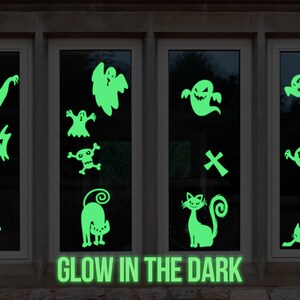 Könnte beinhalten: Vier Fenster mit leuchtenden Halloween-Aufklebern. Die Aufkleber zeigen Geister, Fledermäuse, Katzen und einen Totenkopf mit Knochen. Die Fenster sind mit dunklem Holz umrahmt und der Text "GLOW IN THE DARK" ist unter den Fenstern gedruckt.