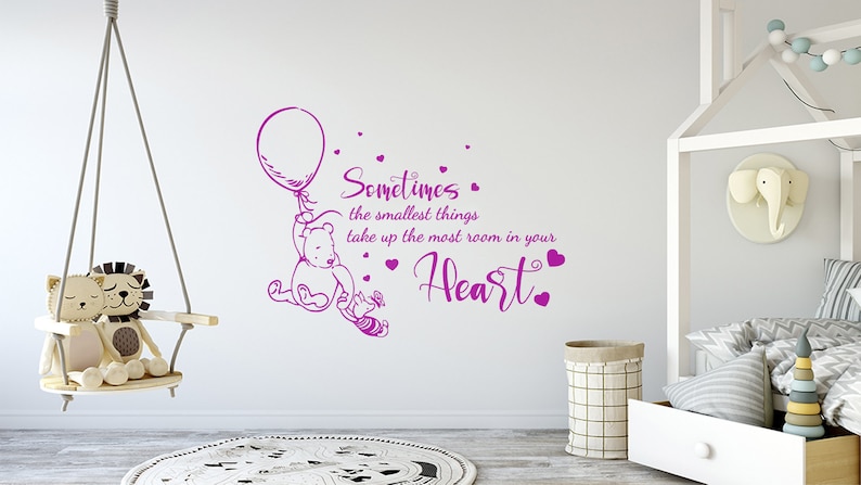May include: Winnie the Pooh and Piglet holding a balloon with the quote "Sometimes the smallest things take up the most room in your heart." in purple lettering on a white wall.