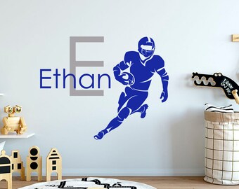 Könnte beinhalten: Blaue und graue Wanddekoration mit einem Footballspieler, der mit dem Ball rennt, dem Buchstaben E und dem Namen Ethan.