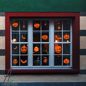 Puede incluir: Una ventana con un marco rojo y un patrón de cuadrícula blanca. La ventana está decorada con recortes de calabaza naranja, murciélagos y telarañas. Los recortes se colocan en los cristales y se iluminan desde atrás, creando un ambiente de Halloween espeluznante.