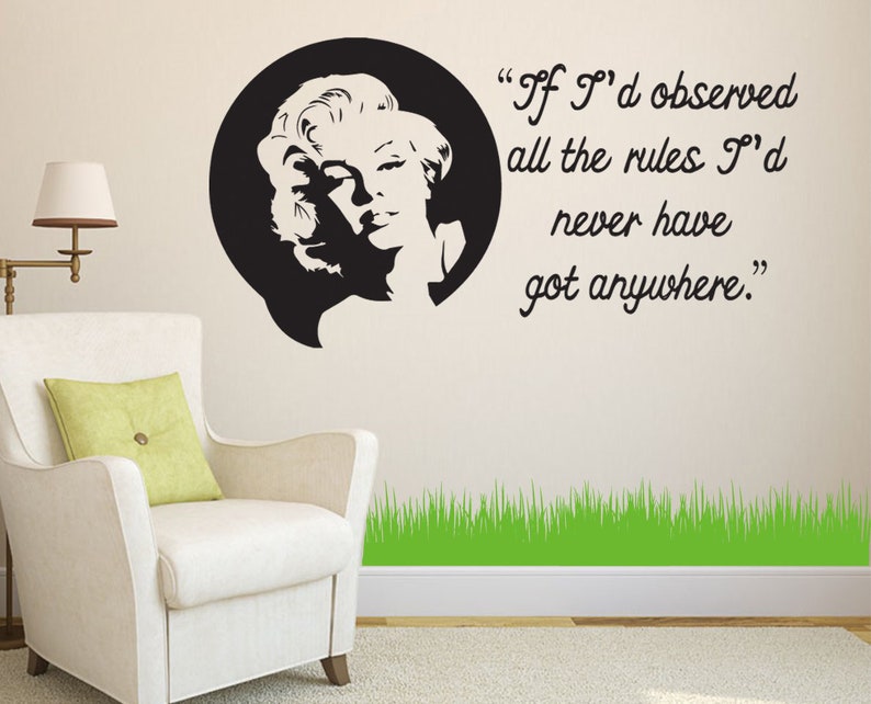May include: Black and white silhouette of a woman with a quote that reads "If I'd observed all the rules I'd never have got anywhere." The quote is in a speech bubble above the woman's head. The background is a white wall with a green grass border at the bottom.