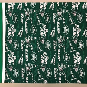 Puede incluir: Tela verde con un patrón blanco repetido del logotipo de los New York Jets, que incluye el nombre del equipo, un balón de fútbol y un casco.