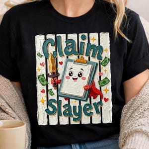 May include: Black t-shirt with a graphic featuring the words "Claim Slayer" in teal and white. The design includes a cartoon clipboard character holding a sword, surrounded by hearts, dollar bills, and stars.