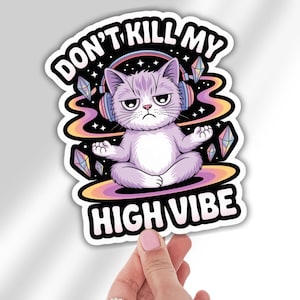 May include: A sticker featuring a cartoon cat meditating with headphones, surrounded by colorful swirls and crystals. The text reads "DON'T KILL MY HIGH VIBE" in a bold, playful font. The cat has a grumpy expression.