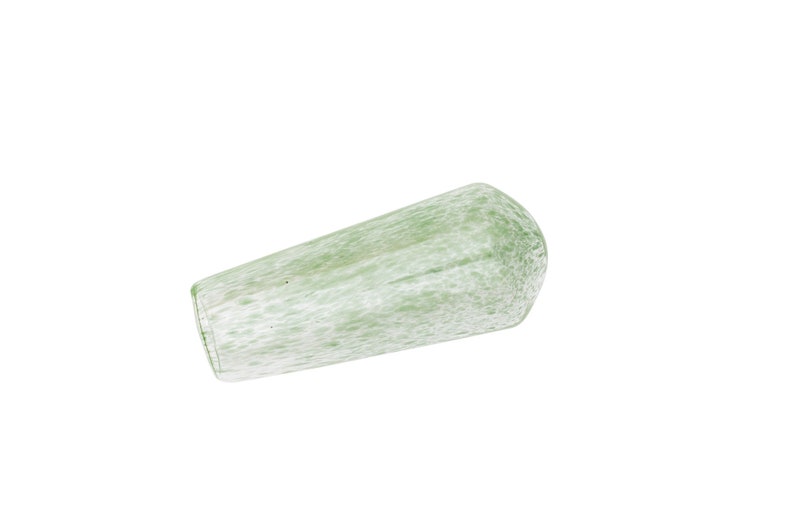 May include: A light green glass drinking glass with a speckled pattern. The glass has a cylindrical shape with a rounded bottom and a flat, open top. The glass is made of a translucent material.